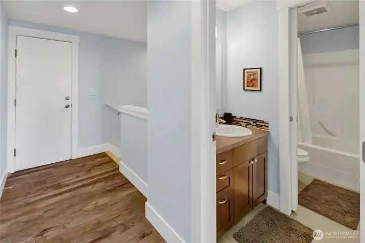 The upstairs full bathroom offers thoughtful functionality with a pocket door separating the tub/shower and toilet area from the sink vanity, allowing multiple users to utilize the space comfortably.