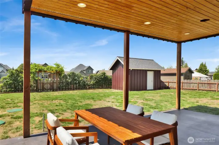 The covered patio is the perfect spot to relax with a glass of lemonade on warm summer days, offering welcome shade and a dry, comfortable outdoor space when the rain arrives.