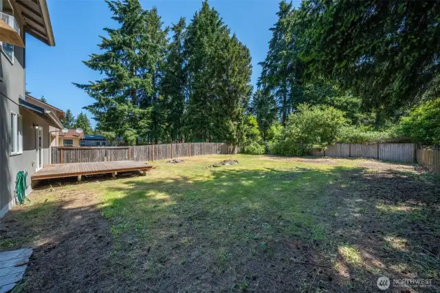 Fully fenced back yard with deck.