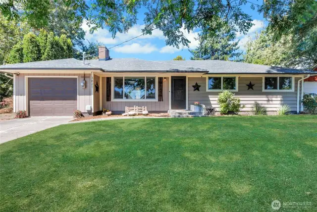 This classic single-story home boasts curb appeal with its expansive front lawn, updated windows, and cozy front porch area. Tasteful exterior accents complete the picture-perfect setting.
