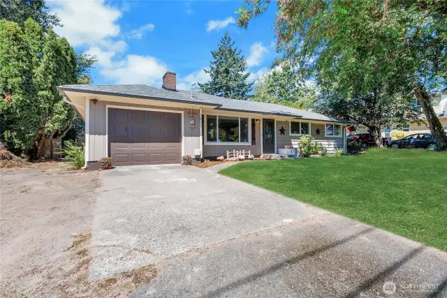 Welcome home! A charming and well-maintained façade with a fresh garage door, manicured garden beds, and a wide driveway offering ample parking. The inviting front entry and mature landscaping create a warm first impression
