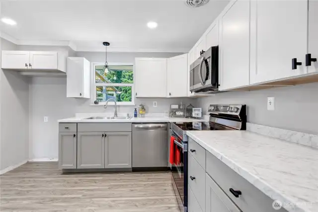 Highlighting the gorgeous countertops, modern hardware, and large window above the sink. This kitchen truly balances style and function—ready for both meal prep and entertaining.