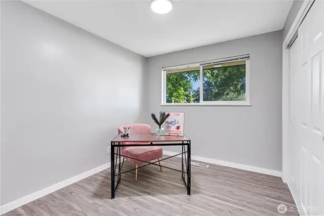 Bright and peaceful, this versatile room is perfect as a home office, guest bedroom, or creative space. Large windows bring in lush green views, while the soft color palette provides a calm, focused atmosphere.