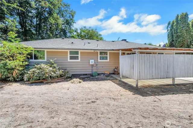 A view of the home's rear exterior, showing newer windows, updated siding, and a clear layout of the backyard and patio area. A great canvas for creating your dream outdoor oasis.