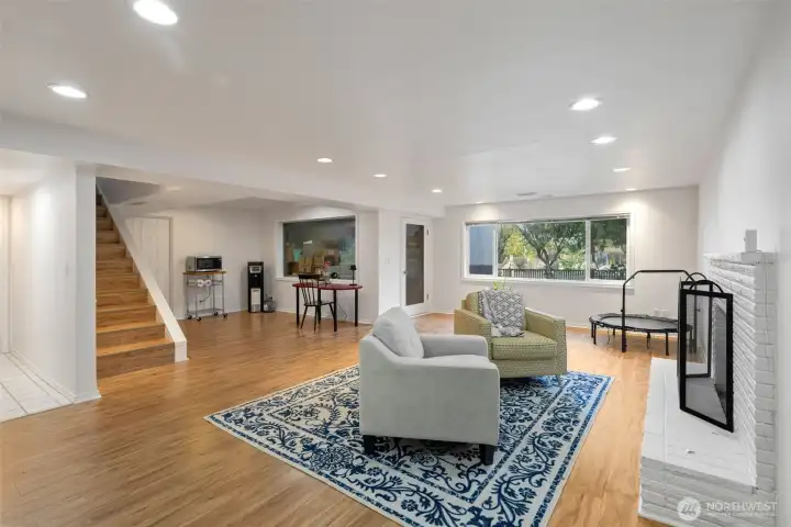 Generous family room with beautifully refinished hardwood floors and a classic wood-burning fireplace