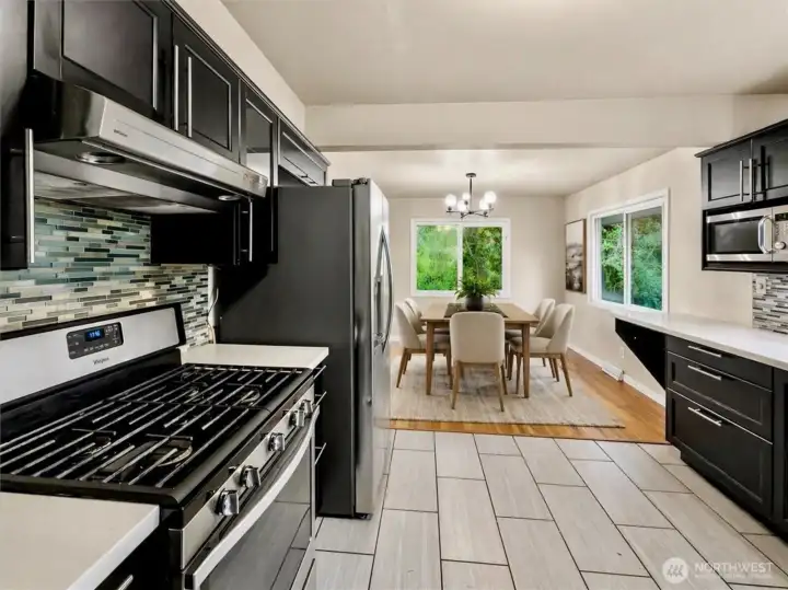 Updated kitchen with quartz counters, tile backsplash and stainless steel appliances. Separate dining area off the kitchen [virtually staged]