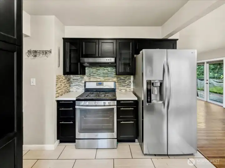 Updated kitchen with quartz counters, tile backsplash and stainless steel appliances.