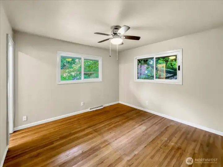 Primary bedroom with real hardwoods, ceiling fan and attached bathroom with shower.