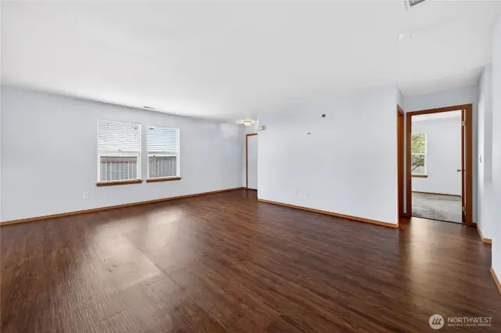 Bright and open living space featuring laminate wood flooring, abundant natural light, and a seamless flow—plus all appliances are included for added convenience.