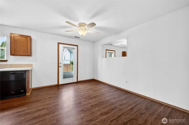The dining area features a ceiling fan and flows effortlessly between the kitchen and living room, with direct access to the backyard and patio for easy indoor-outdoor living.