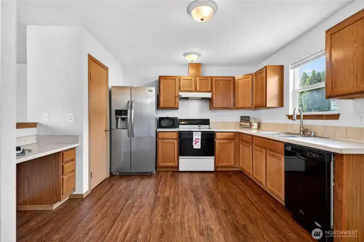 The open kitchen offers a built-in work area, pantry, and generous cabinet and counter space—designed for both everyday living and entertaining.