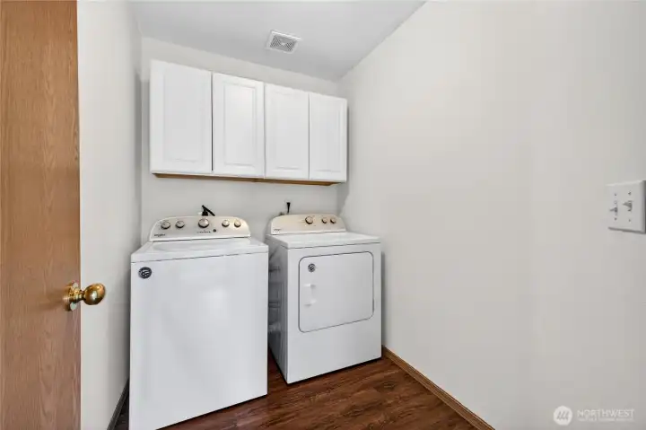 Good size utility room with built-in cabinets for convenience and extra storage.