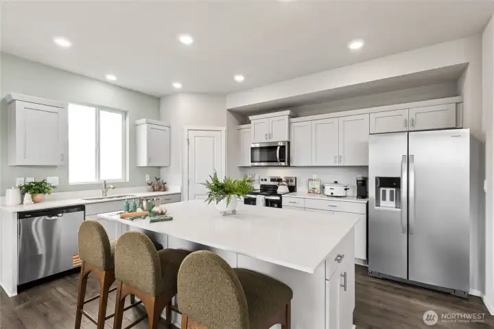 Modern kitchen with quartz countertops, soft close shaker style cabinetry, and stainless-steel appliances. **Photo is representational. Actual home is under construction. Colors, materials, and features may vary. See site agent for details.**