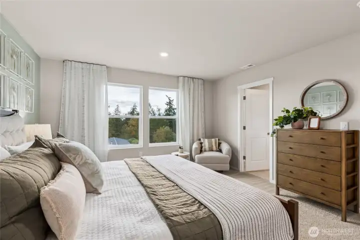 Huge primary bedroom with space for a King size mattress, nightstands, dressers, televisions, and accent furniture. **Photo is representational. Actual home is under construction. Colors, materials, and features may vary. See site agent for details.**