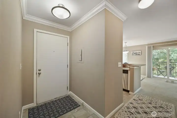 Well lit, traditional entry with slate style flooring, crown molding & electrical panel leads to the open concept living areas and adjacent coat closet