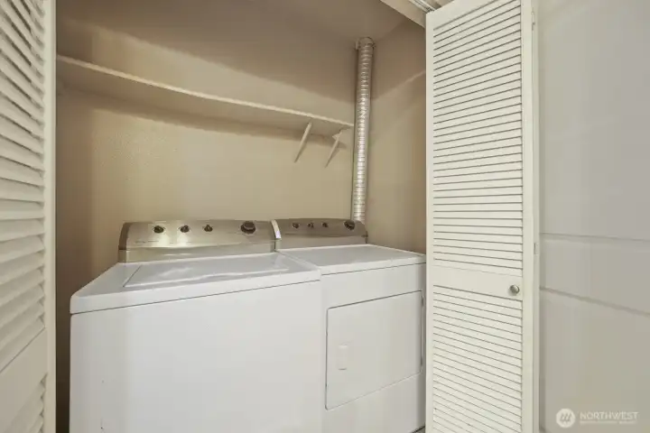 Laundry closet features Full size Frigidaire washer & dryer with shelf
