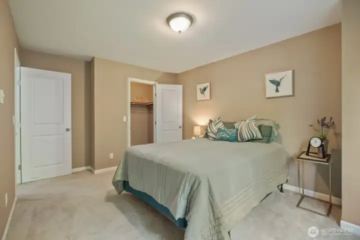 Primary bedroom with updated, 2 panel doors, white trim, sizeable walk-in closet with built-in shelf- this will accommodate your CA king!