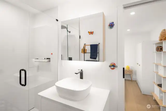This crisp white bathroom is shared between two bedrooms.