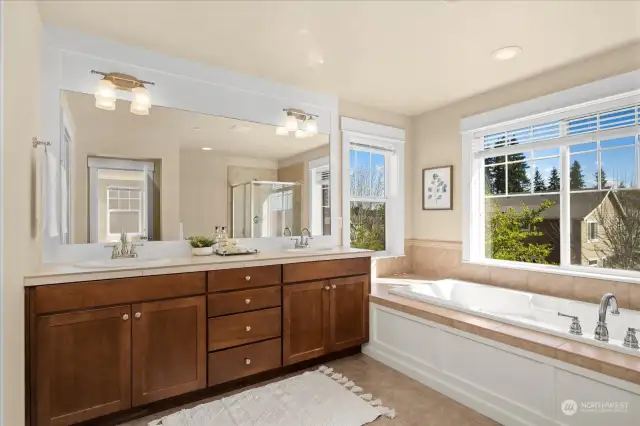 Sun-drenched Primary bath with dual vanities, large soaking tub.