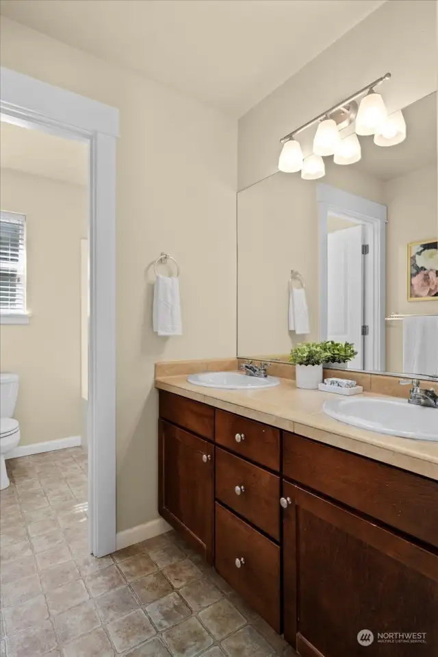 Upstairs Guest bath with dual vanities is so convenient. Tons of cabinetry for storage.