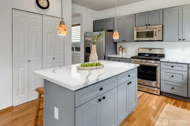The sunny kitchen features a large island with bar seating, and a kitchen pantry.
