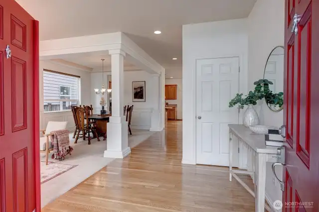 Step through grand double doors into a stunning two-story foyer, bathed in natural light and framed by an open hallway above.