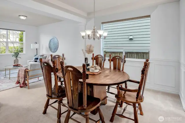 Dining room with wainscoting and a coffered ceiling set the stage for memorable gatherings.