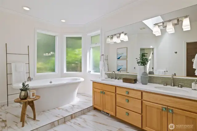 Primary bathroom with dual vanity and soaking tub.