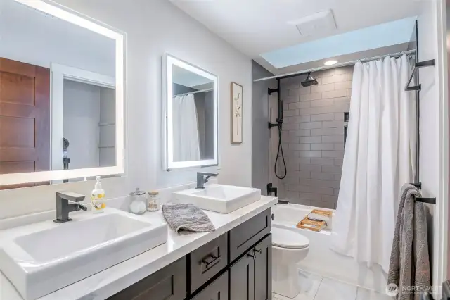 Upper hall bath completely updated with tile, double vanity, skylight and large closet