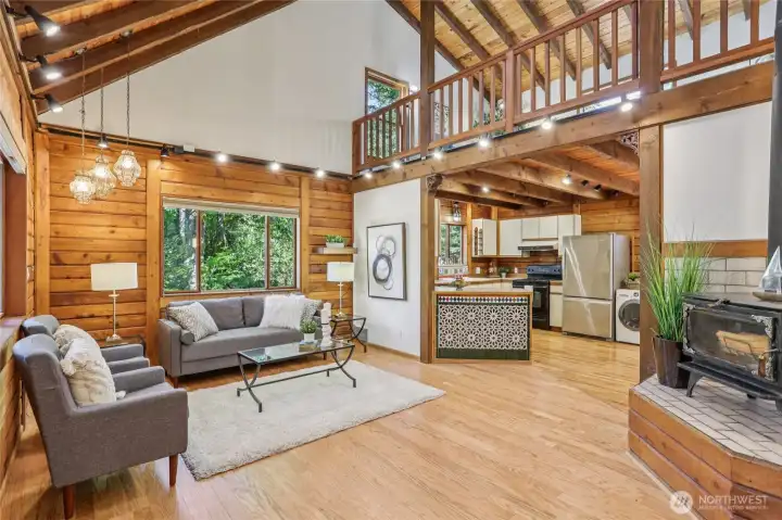 Soaring ceilings and skylights brighten the living room, while a wood-burning stove creates warmth and charm.