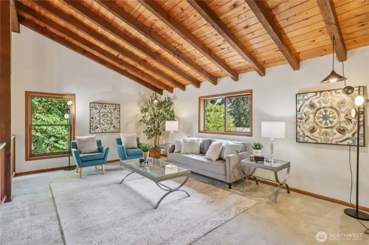 Bright and airy loft highlighted by vaulted ceilings, exposed beams, and plenty of natural sunlight.