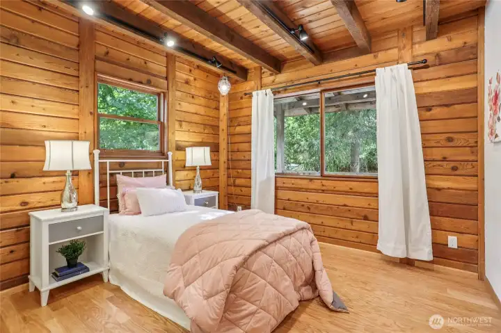 Main level guest suite highlighted by warm timber-lined walls.