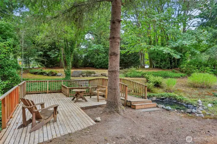 Charming outdoor seating area for morning coffee or entertaining, complemented by your own private pond and a stream that flows in winter