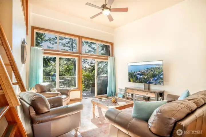 Through the entry past the kitchen is the living room - the ceiling here vaults with additional windows for sunny exposure towards the southside.