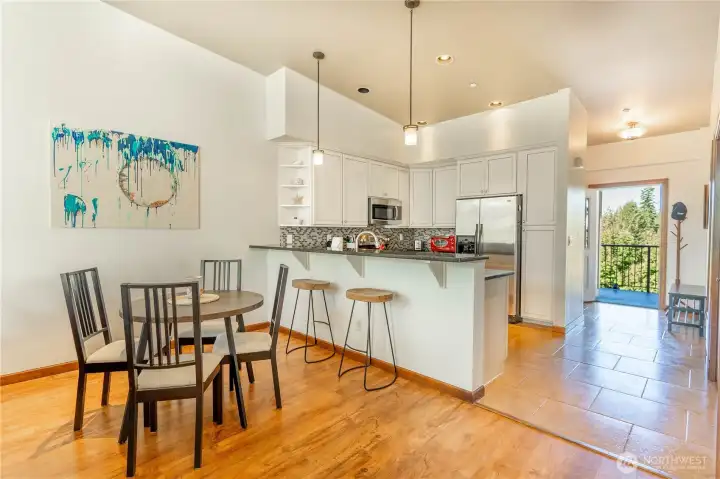 Dining table shown here with a granite eating bar that could accommodate four barstools as well.