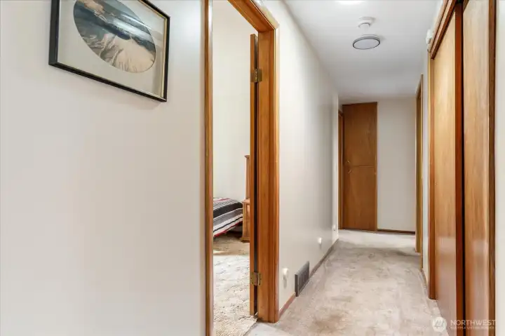 Hallway to bedrooms. Large closet and additional linen closet at the end.