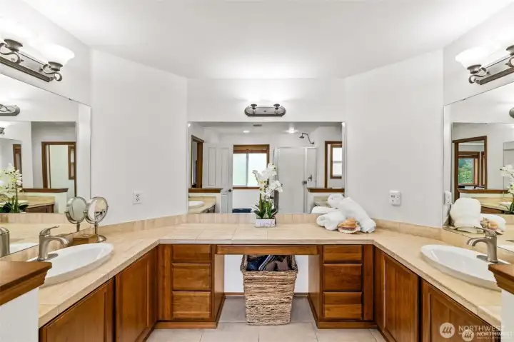 Relaxing primary bath with dual vanities and plenty of light.