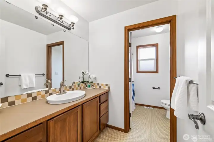 This upstairs full bath offers a fresh feel and functional layout for everyday use.