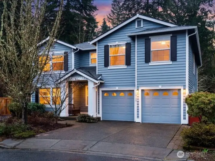 Dusk sets in on this beautiful home with new exterior paint in a soft blue gray, with two accent colors, highlighting all the exterior trim details