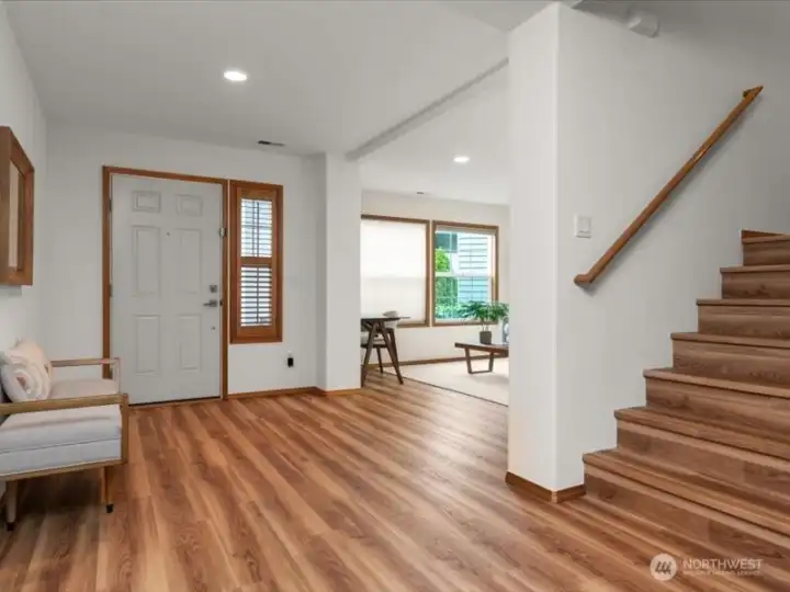 Expansive entry hallway with space for bench and warm wood-like LV flooring creating an inviting sense of entry