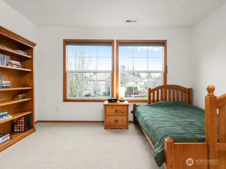 Roomy secondary bedroom, accommodates a queen-sized bed and offers birds eye front yard and neighborhood views