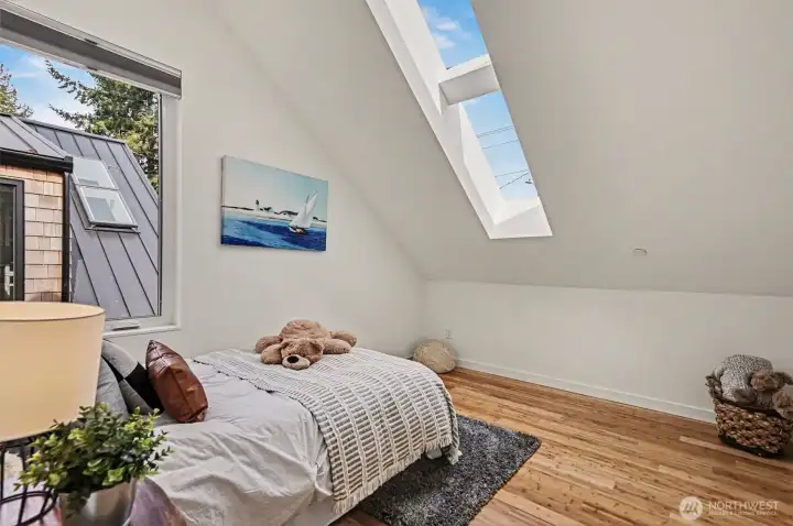 Upstairs bedroom showcasing bamboo flooring and skylight.