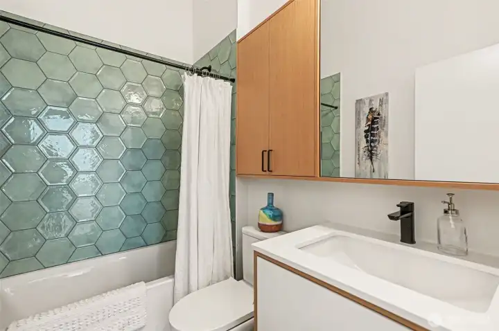 Similar in design/style, the upper level bathroom has a tub.