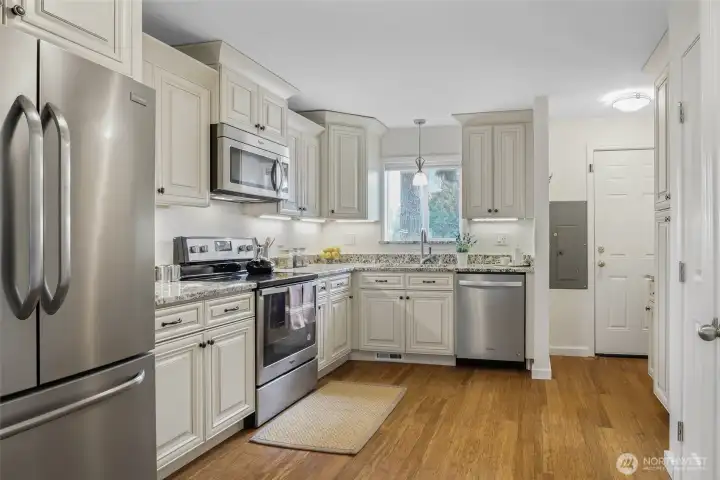 Bright, spacious kitchen with custom cabinetry, stainless steel appliances and its own exterior door for easy outdoor access