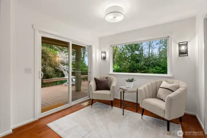 Added on in 2008, the breakfast nook with a large garden view window and slider to the deck is staged as a sitting area