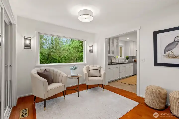 The breakfast nook, staged as a sitting area with view out the garden view window. The kitchen is to the right.