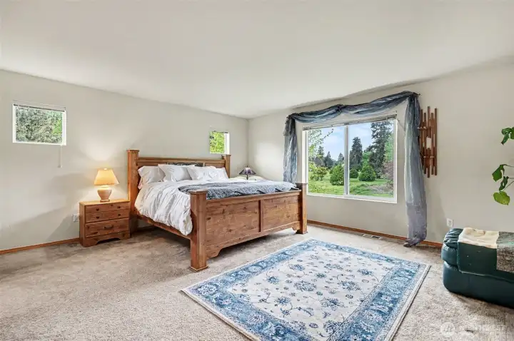 Spacious primary suite with picture window overlooking the yard and golf course.