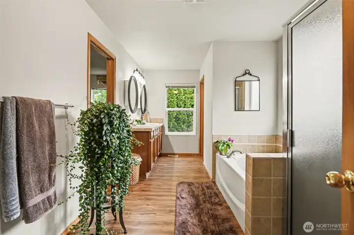Primary suite's attached 5 piece bath with new vinyl plank flooring and spacious walk in closet.