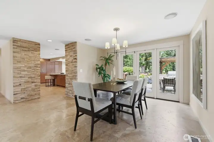 The open dining area feautres Travertine flooring & French doors to the patio for easy indoor/outdoor entertaining.