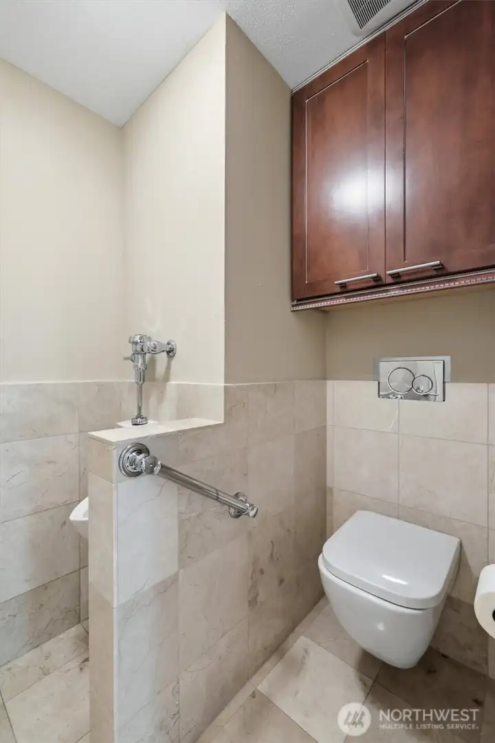 Separate water closet in the primary bath with grab bar for easy accessibility.